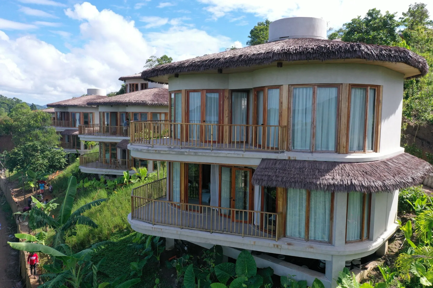 Aerial view of Atalaya Resort's thatched-roof villas on the forested El Nido hillside