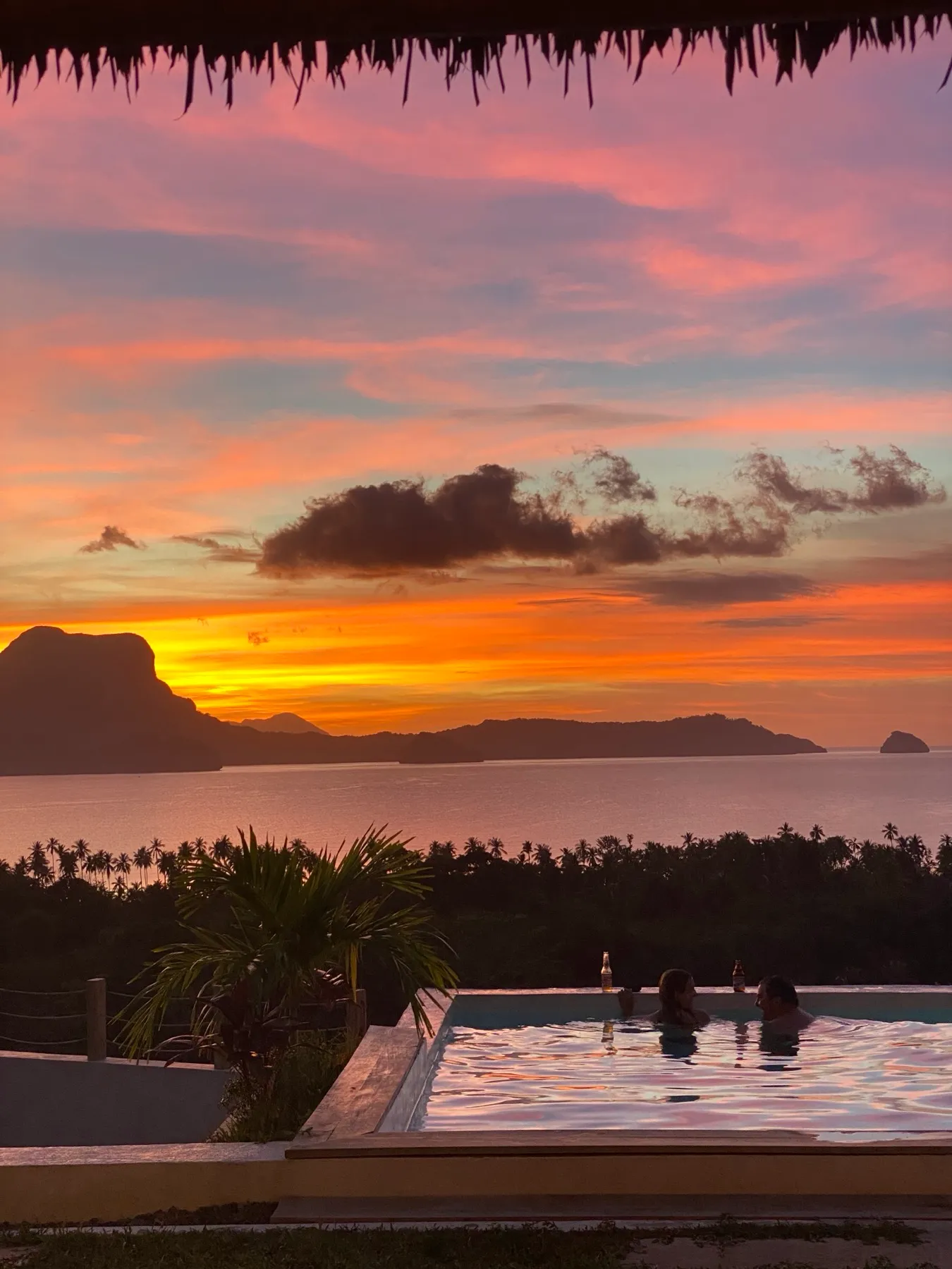 Guests in the infinity pool at sunset, Atalaya Resort, El Nido