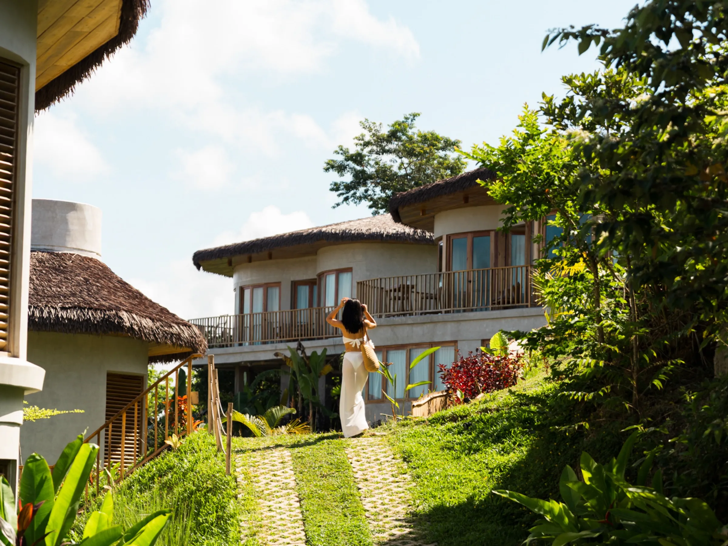 A guest walking the garden path between the villas at Atalaya Resort